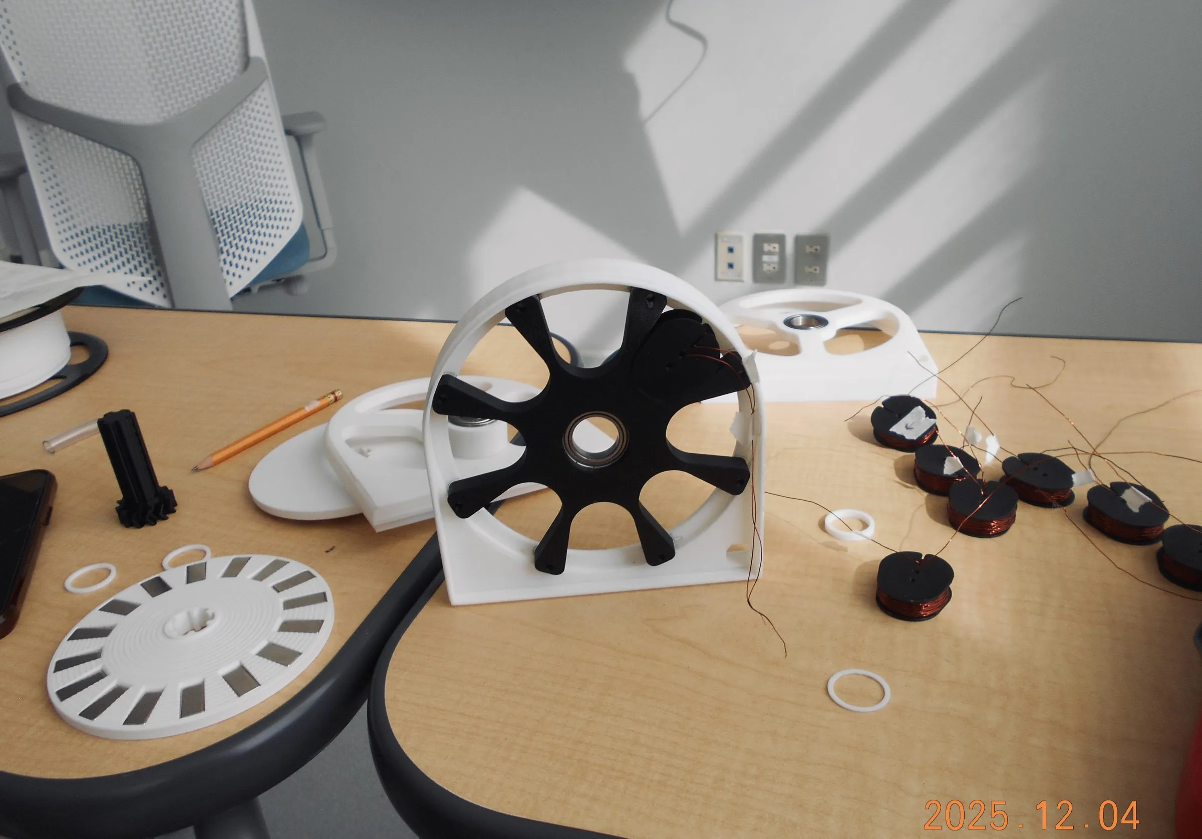 3D-printed parts and coils on a workbench